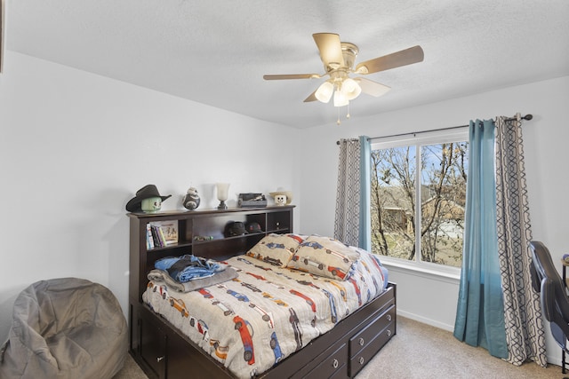 bedroom with ceiling fan, light carpet, multiple windows, and a textured ceiling