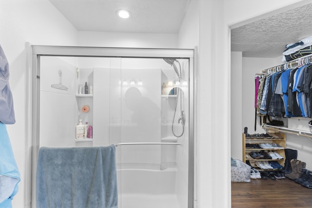 bathroom featuring hardwood / wood-style floors, a textured ceiling, and walk in shower