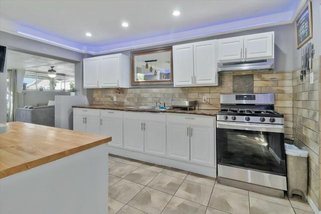 121 Hosher Ave SE, Albuquerque, NM 87102 - kitchen featuring stainless steel gas stove, under cabinet range hood, butcher block countertops, white cabinetry, and recessed lighting