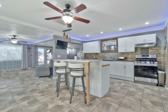 121 Hosher Ave SE, Albuquerque, NM 87102 - kitchen featuring stainless steel gas range, under cabinet range hood, ceiling fan, backsplash, and recessed lighting