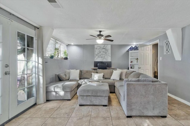 tiled living room with ceiling fan and a textured ceiling