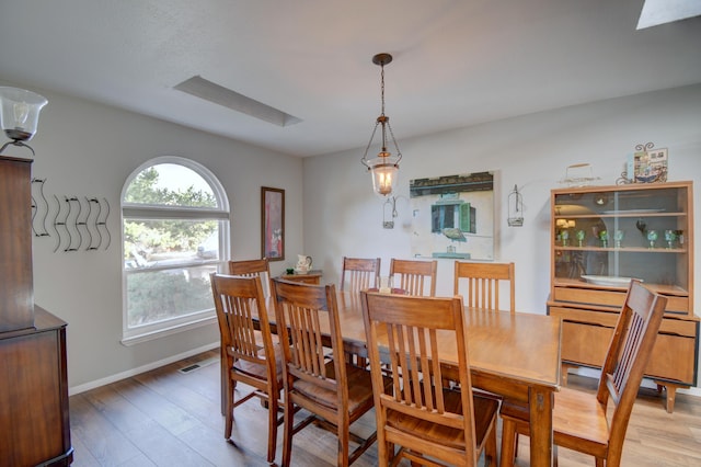 dining space featuring visible vents, baseboards, and light wood-style floors