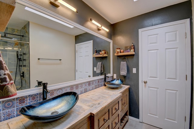 bathroom with a sink, double vanity, and a shower stall