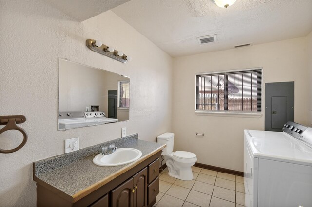 bathroom with tile patterned flooring, washer and dryer, electric panel, and vanity