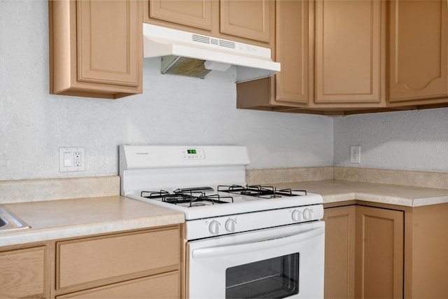 kitchen featuring light brown cabinetry and white range with gas cooktop