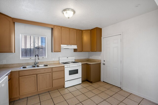 kitchen with a textured ceiling, sink, light tile patterned floors, and white appliances