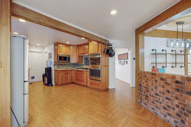 kitchen featuring appliances with stainless steel finishes, light stone counters, light parquet floors, pendant lighting, and beam ceiling