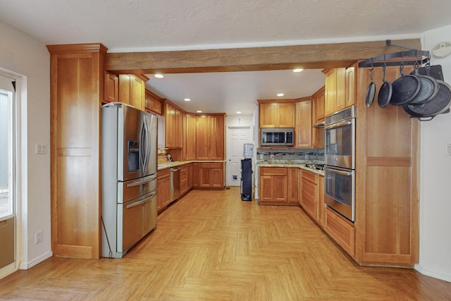 kitchen with backsplash, light stone counters, stainless steel appliances, beam ceiling, and light parquet flooring