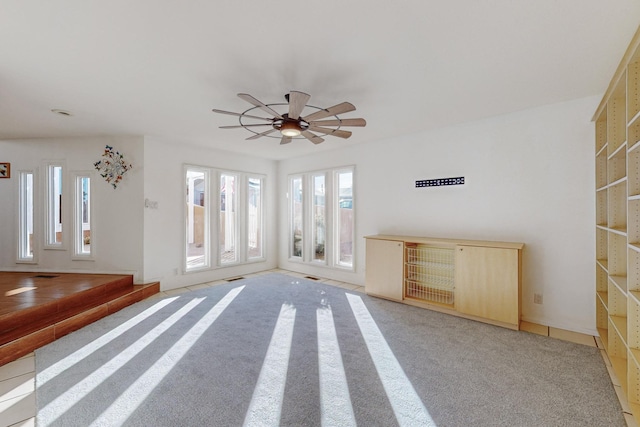 unfurnished living room with carpet flooring and ceiling fan