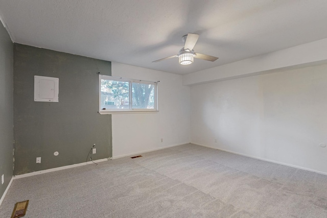 carpeted spare room featuring ceiling fan and electric panel