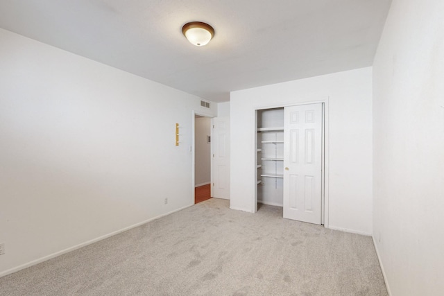 unfurnished bedroom with light carpet and a closet