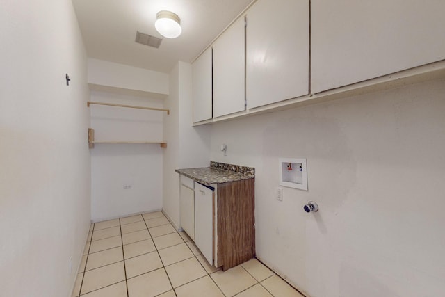 clothes washing area with washer hookup, light tile patterned flooring, and cabinets