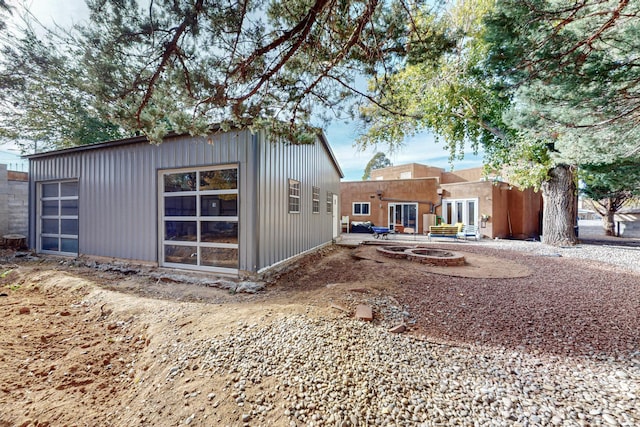 rear view of property featuring an outdoor fire pit