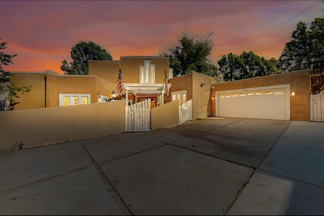 pueblo-style house featuring a garage