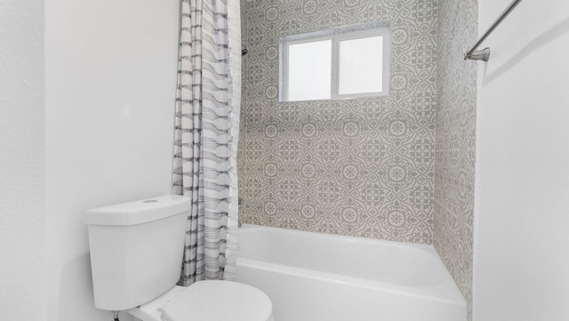 bathroom with toilet and shower / bath combo with shower curtain