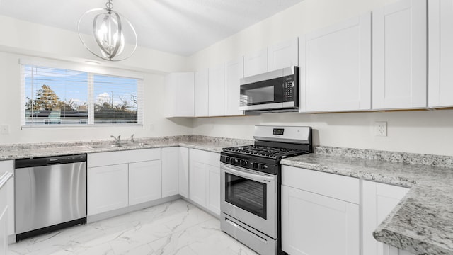 kitchen featuring pendant lighting, sink, white cabinetry, and stainless steel appliances