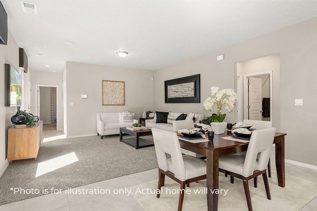 dining area featuring a textured ceiling and light colored carpet