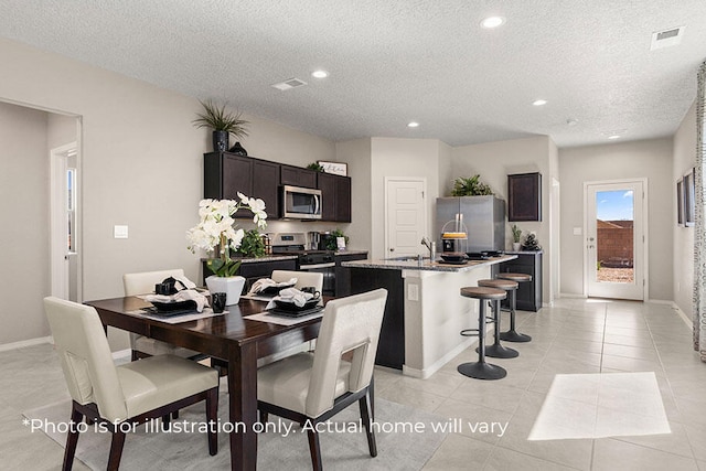 dining space featuring light tile patterned floors and a textured ceiling