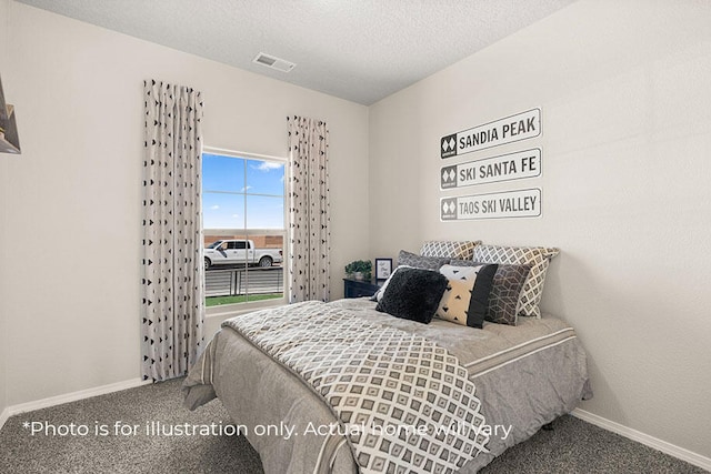 bedroom with carpet floors and a textured ceiling