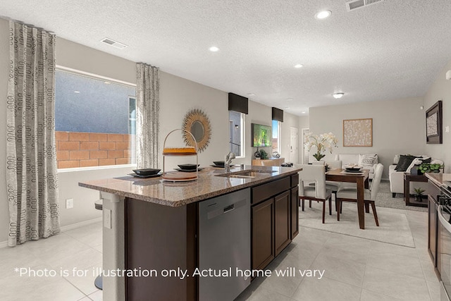 kitchen with stainless steel dishwasher, sink, an island with sink, and a wealth of natural light