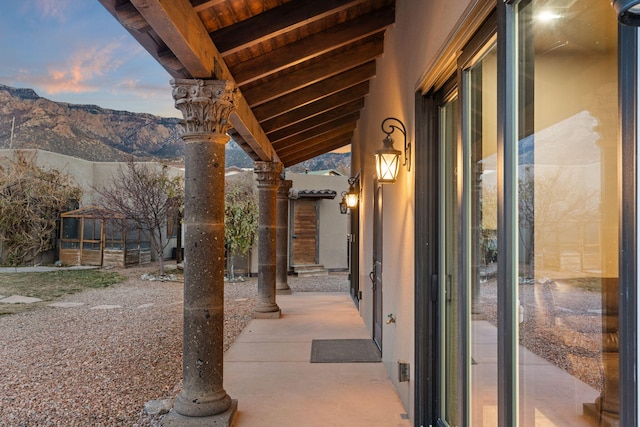 patio terrace at dusk featuring a mountain view