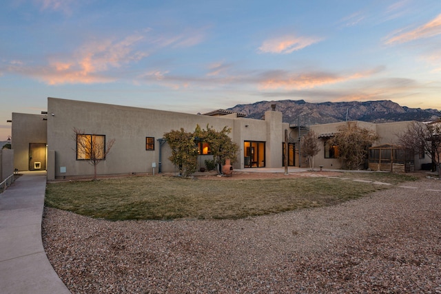 southwest-style home featuring a lawn and a mountain view