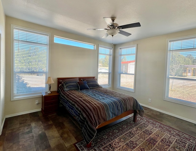 bedroom featuring ceiling fan, dark hardwood / wood-style floors, and a textured ceiling