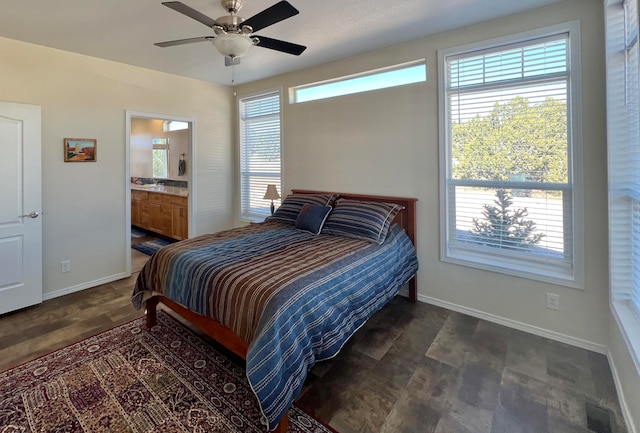 bedroom with connected bathroom, multiple windows, and ceiling fan