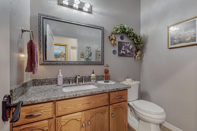 bathroom featuring toilet and vanity