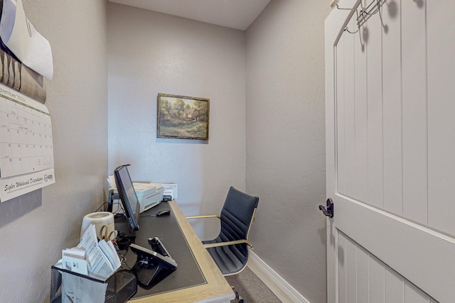 office area featuring a textured wall and baseboards