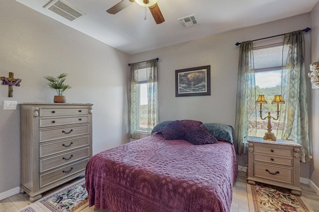 bedroom with visible vents, light wood-style flooring, and baseboards