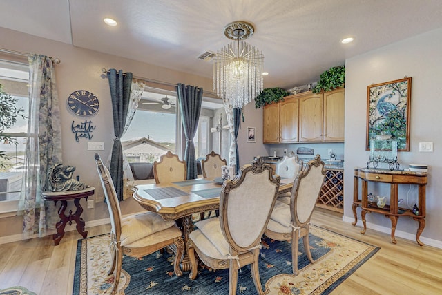 dining space with recessed lighting, baseboards, light wood finished floors, and an inviting chandelier