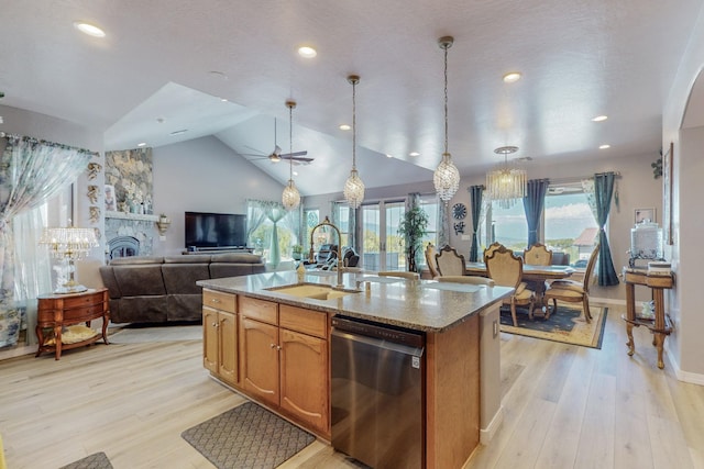 kitchen featuring light wood-style floors, a sink, light stone counters, and stainless steel dishwasher