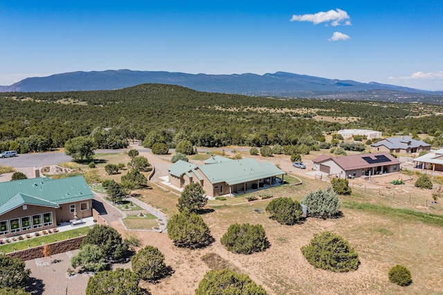 birds eye view of property with a mountain view and a forest view