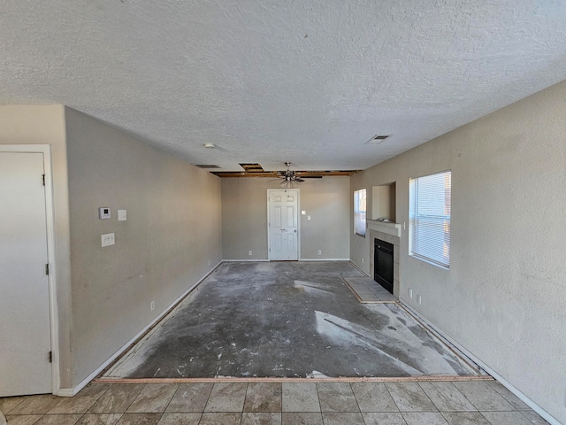 unfurnished living room with a textured ceiling and ceiling fan