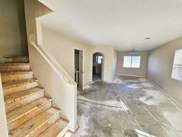 entrance foyer featuring a textured ceiling and a chandelier