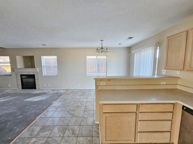 kitchen with plenty of natural light, dishwasher, light brown cabinetry, and a chandelier