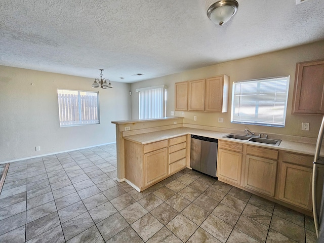 kitchen with kitchen peninsula, stainless steel dishwasher, a healthy amount of sunlight, and sink