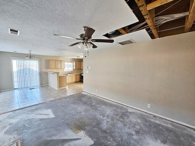 unfurnished living room featuring ceiling fan, sink, and a textured ceiling