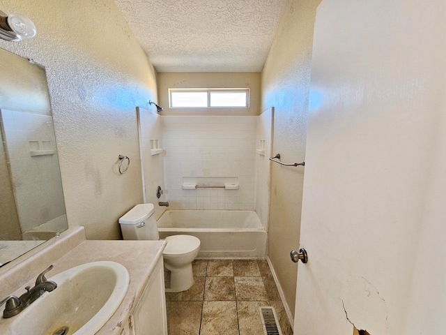 full bathroom with vanity, a textured ceiling, toilet, and tiled shower / bath