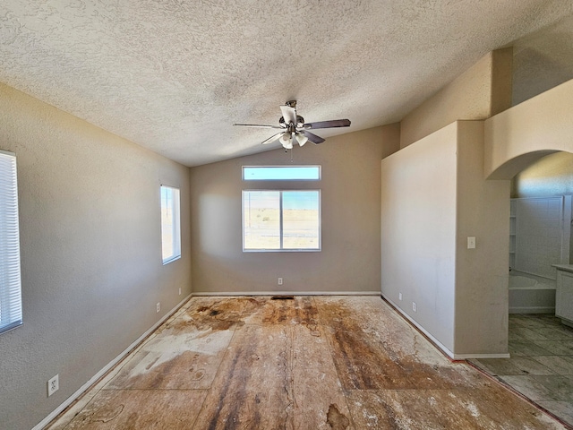 spare room featuring hardwood / wood-style floors, a textured ceiling, ceiling fan, and lofted ceiling