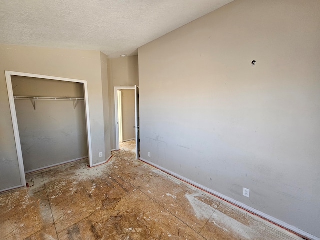 unfurnished bedroom featuring a textured ceiling and a closet