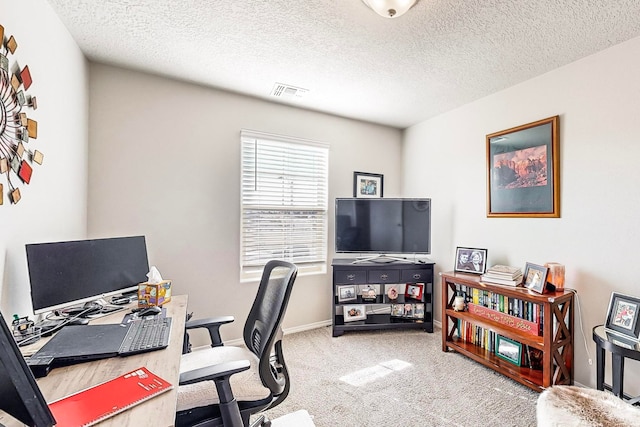 carpeted office featuring a textured ceiling