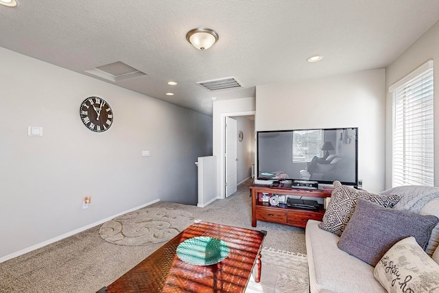 carpeted living room featuring a textured ceiling