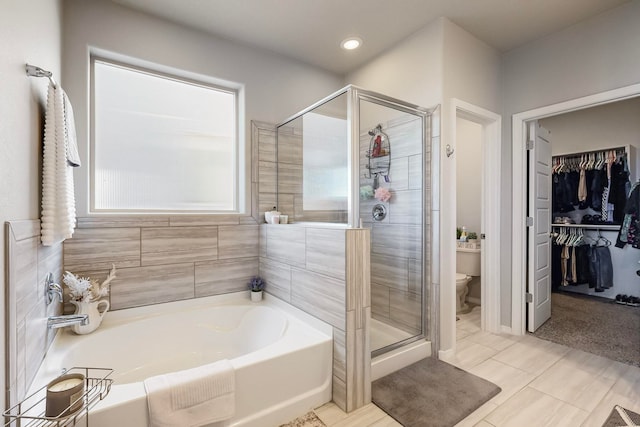 bathroom featuring tile patterned flooring, separate shower and tub, and toilet