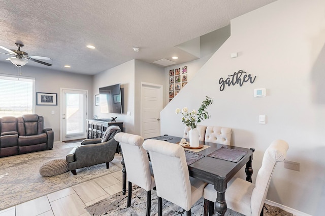 tiled dining space with ceiling fan and a textured ceiling