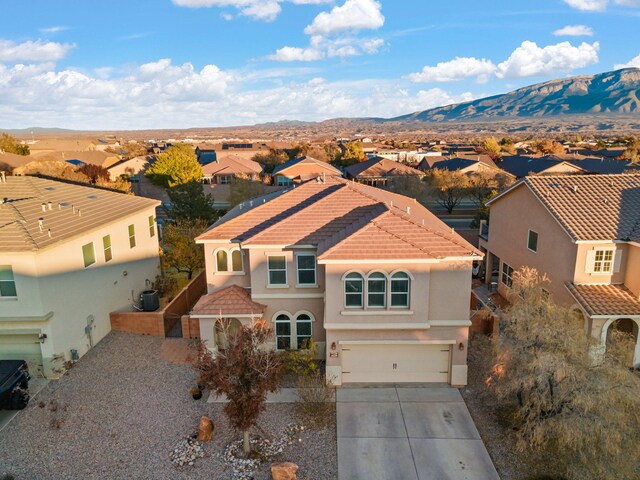 6923 Wrangell Loop NE, Rio Rancho, NM 87144 - mediterranean / spanish house featuring a residential view, driveway, a mountain view, a garage, and a tile roof