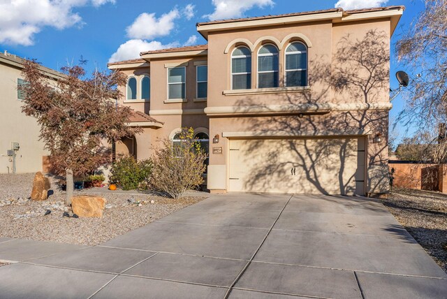 6923 Wrangell Loop NE, Rio Rancho, NM 87144 - mediterranean / spanish house featuring stucco siding, an attached garage, a tiled roof, and driveway
