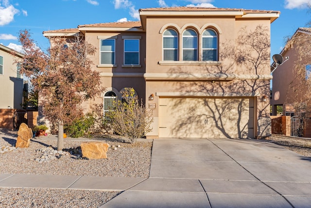 6923 Wrangell Loop NE, Rio Rancho, NM 87144 - mediterranean / spanish home with stucco siding, an attached garage, driveway, and a tile roof