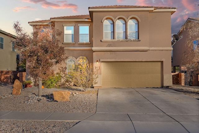 6923 Wrangell Loop NE, Rio Rancho, NM 87144 - mediterranean / spanish house featuring an attached garage, driveway, stucco siding, and a tiled roof